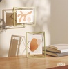 image:imageUmbra Prisma Picture Frame Floating Metal Wall Mount 5x7 Brass  Steel wire construction unique geometric shape displays photo between glass desk or tabletop use hardware includedBrass