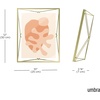 image:imageUmbra Prisma Picture Frame Floating Metal Wall Mount 5x7 Brass  Steel wire construction unique geometric shape displays photo between glass desk or tabletop use hardware includedBrass