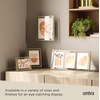 image:imageUmbra Prisma Picture Frame Floating Metal Wall Mount 5x7 Brass  Steel wire construction unique geometric shape displays photo between glass desk or tabletop use hardware includedBrass